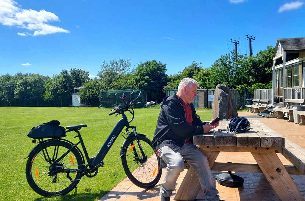 the rider sits and sees his phone after riding Eskute Polluno e-bike