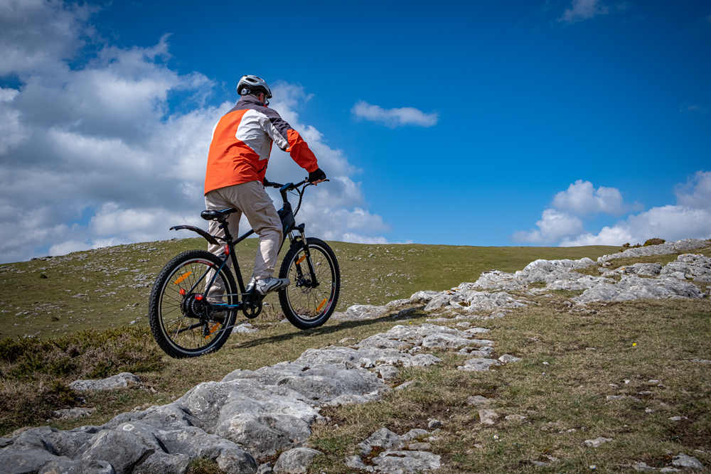 A heavy man rides an electric mountain bike on a slope