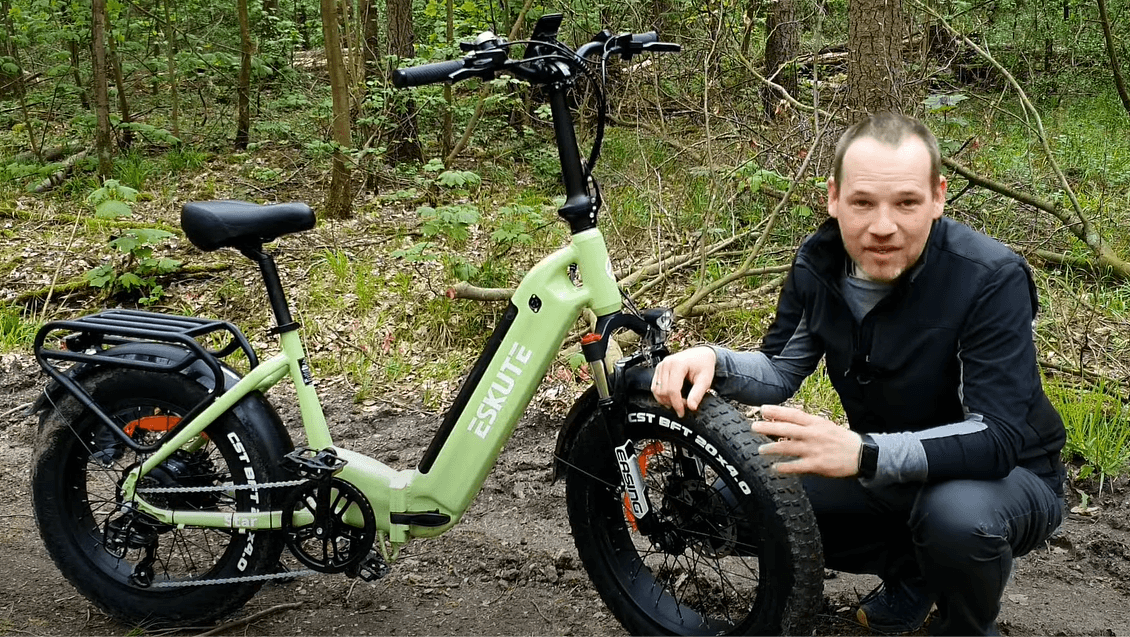 A man is preparing to ride a folding electric bicycle outdoors