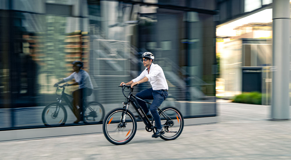 a man with helmet is riding his electric bike in the city