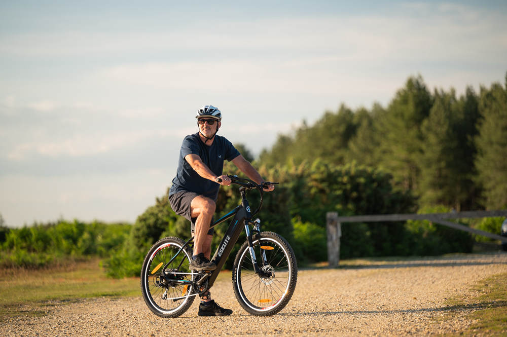 a man with helmet sits on the ebike