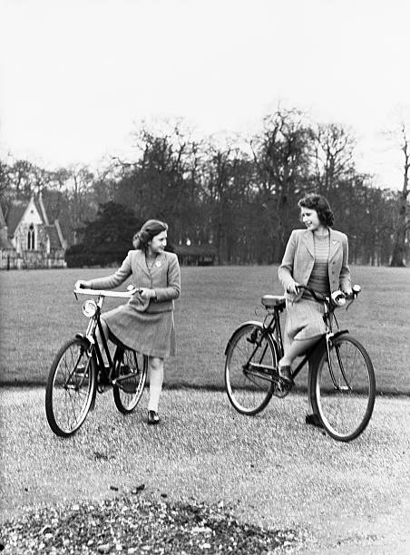 young Elizabeth riding her bike with her sister